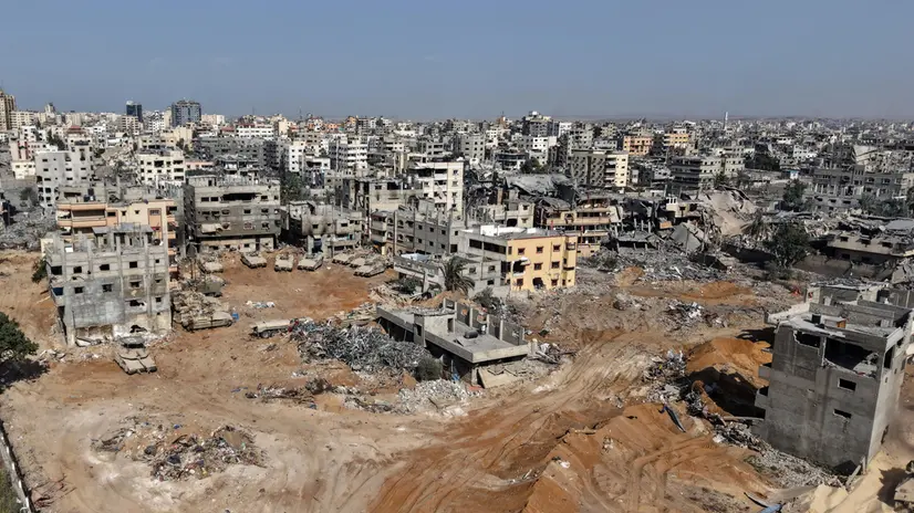 epa12430671 A photo taken while embedded with the Israeli Army and cleared by Israeli military censors shows Israeli army tanks and armoured personnel carriers stationed amid damaged buildings in the vicinity of the Jordanian Field Hospital in Gaza City, 03 October 2025 (issued 04 October 2025). Israel's military said on 04 October to advance readiness for the implementation of the first phase of the Trump plan for the release of the hostages while the same time make the safety of IDF troops a top priority and allocate all IDF capabilities to the Southern Command to ensure the protection of the troops. EPA/JACK GUEZ / POOL --PHOTO TAKEN DURING A CONTROLLED TOUR AND SUBSEQUENTLY EDITED UNDER THE SUPERVISION OF THE ISRAELI MILITARY--
