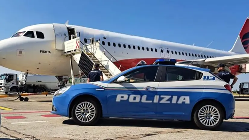 Un'auto della Polizia e un aereo per i rimpatri