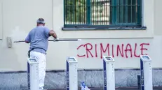 Gli operai ripuliscono la facciata della sede dell'Agenzia delle Entrate di via Padova, Torino, dopo l'assalto dei No Vax nella notte del 16 settembre 2022 ANSA/JESSICA PASQUALON