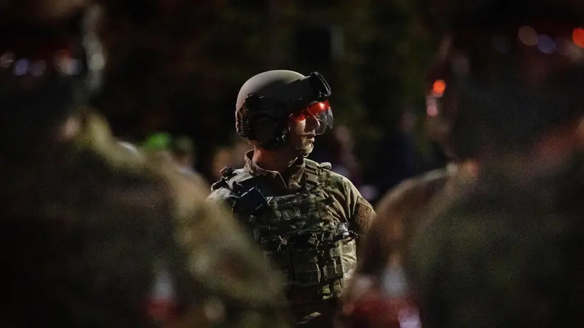 epa08799785 A soldier with the National Guard watches as antifascist protesters refuse to obey a dispersal order following the US presidential elections in Portland, Oregon, USA, 04 November 2020. Portland Police declared a riot resulting in the activation of the National Guard. EPA/CHRISTIAN MONTERROSA