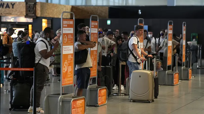 epa10116910 Passengers wait in line at a check-in desk at El Prat Airport in Barcelona, Spain, 12 August 2022. The first day of the EasyJet pilots' strike in August has caused cancellations at El Prat and in Palma de Mallorca Airports. EPA/ALEJANDRO GARCIA