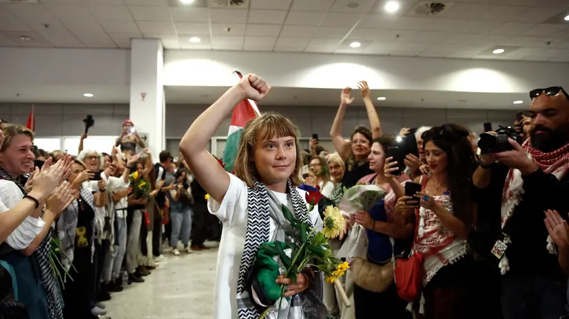 epaselect epa12435319 Swedish activist Greta Thunberg raises her fist as she arrives among 134 citizens from 15 European countries, including 27 Greek citizens, at the Eleftherios Venizelos Greek international airport at Spata, near Athens, Greece, 06 October 2025. According to a statement by the Ministry of Foreign Affairs, at the request of the MFA, and in coordination with the Embassy of Greece in Tel Aviv, a special flight for the repatriation of the 27 Greek citizens and also 134 citizens from 15 European countries, who participated in the Global Sumud Flotilla arrived safely in Athens. EPA/YANNIS KOLESIDIS