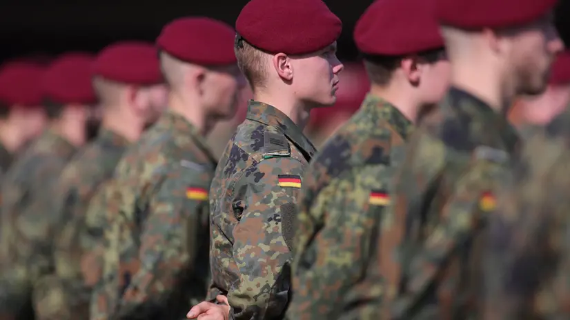 epa09481379 Soldiers of the German Bundeswahr stand before the arrival of Chancellor Angela Merkel during a muster for the soldiers of the evacuation mission from Kabul at the paratroopers barracks in Seedorf, northern Germany, 22 September 2021. The airlift between the Afghan capital Kabul and the Uzbek city of Tashkent was the biggest ever evacuation mission of the German Bundeswehr. EPA/FRIEDEMANN VOGEL