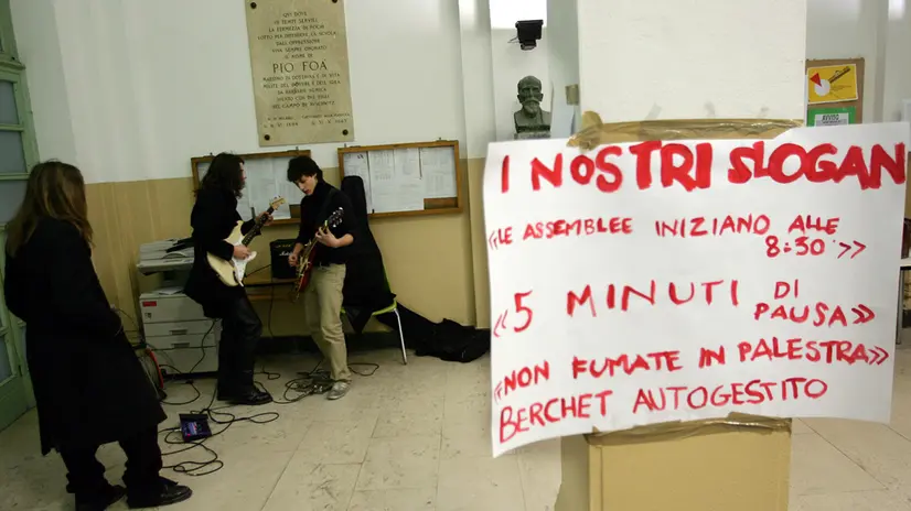 MI-1-19712/05- MILANO- CRO-SCUOLA: MILANO; BRUCIATI ASCIUGAMANI BAGNI, EVACUATO BERCHET. Due studenti suonano la chitarra nell'atrio del Liceo Berchet, dopo il principio d'incendio che si ? verificato in tarda mattinata al liceo Berchet. DANIEL DAL ZENNARO