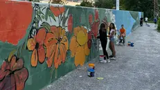 Ragazzi al lavoro sul muro che costeggia la ciclabile