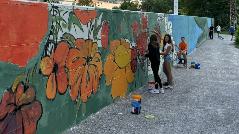 Ragazzi al lavoro sul muro che costeggia la ciclabile