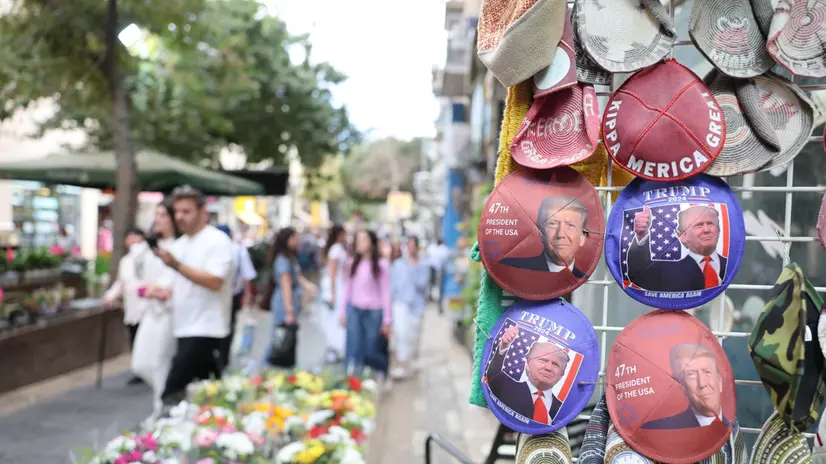 epa12444453 People walk past a shop selling Jewish skullcaps, known as a kippah (Hebrew) or yarmulke (Yiddish), featuring an image of U.S. President Donald Trump at a market in Jerusalem, Israel, 10 October 2025. Israeli Parliament Speaker Amir Ohana has invited Trump to deliver a speech at the Knesset. EPA/ABIR SULTAN