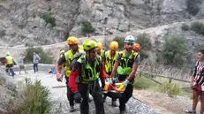 Recupero di un escursionista che si trovava nelle Gole del Raganello dove la piena del torrente ha provocato vittime, Civita (Cosenza), 20 agosto 2018. Sarebbero cinque, secondo la protezione civile nazionale, i morti provocati dall'ondata del torrente Raganello a Civita. Tra loro una giovane ragazza non ancora identificata ed il cui corpo è stato recuperato. Altre 12 persone sono state individuate e sono in corso le operazioni di recupero da parte dei vigili del fuoco e del soccorso alpino. ANSA/ANTONIO IANNICELLI