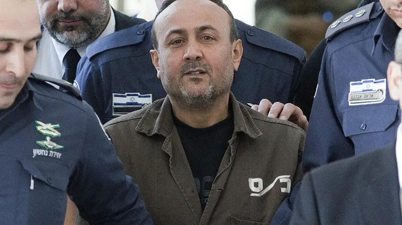 epa03077319 Handcuffed Palestinian Fatah leader Marwan Barghouti is escorted by Israeli police to the Magistrate Court in Jerusalem, 25 January 2012, after testifying in a US civil lawsuit against the Palestinian leadership. Barghouti, sentenced to life imprisonment in 2002 for being involved in anti-Israeli attacks when he led the Tanzim, a Fatah's militant faction, during the Second Intifada in 2000, was cited as saying that the Middle East conflict would only end only when Israel withdraws to the pre-1967 borderlines and a Palestinian state was established. Barghouti refused to testify in court today. EPA/ABIR SULTAN