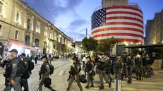 epa12448810 Police officers walk past a building displaying a large US flag ahead of a visit by US President Trump to Israel, in Jerusalem, 12 October 2025. According to a parliament spokesperson for the Israeli Knesset, President Trump will deliver a speech at the Knesset on 13 October 2025 in light of a ceasefire and hostages release deal between Israel and Hamas. The first phase of the Gaza peace plan includes the release of Israeli hostages and Palestinian prisoners, a partial withdrawal of Israeli forces, and the delivery of humanitarian aid to Gaza. EPA/ABIR SULTAN