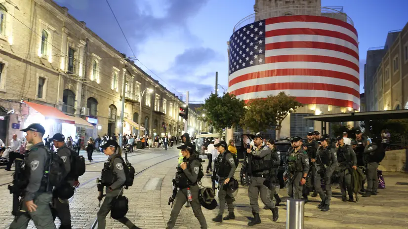 epa12448810 Police officers walk past a building displaying a large US flag ahead of a visit by US President Trump to Israel, in Jerusalem, 12 October 2025. According to a parliament spokesperson for the Israeli Knesset, President Trump will deliver a speech at the Knesset on 13 October 2025 in light of a ceasefire and hostages release deal between Israel and Hamas. The first phase of the Gaza peace plan includes the release of Israeli hostages and Palestinian prisoners, a partial withdrawal of Israeli forces, and the delivery of humanitarian aid to Gaza. EPA/ABIR SULTAN
