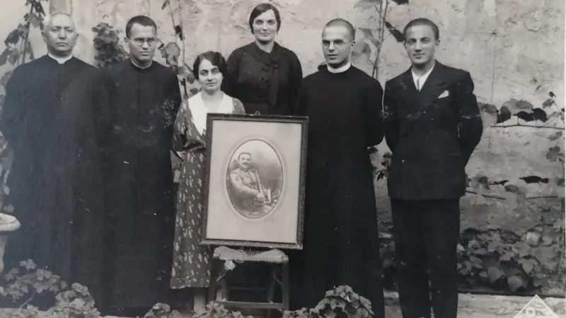 Maria, con i figli, posa con la foto del marito defunto - © www.giornaledibrescia.it