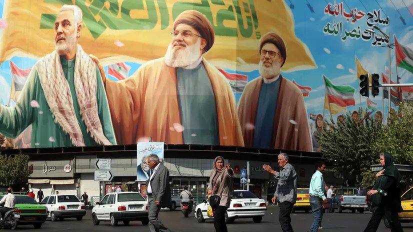 epa12449983 Iranians walk past a billboard depicting Hezbollah's former leader Hassan Nasrallah (C), Sheikh Safieddin (R), and late Iranian commander Qasem Soleimani (L), in Tehran, Iran, 13 October 2025. According to the Iranian Foreign Ministry, the country decided not to participate in the Gaza (Sharm el-Sheikh) Summit, adding that 'as long as the right of self-determination for Palestinians is not realized, we cannot be hopeful about solving the issue.' EPA/ABEDIN TAHERKENAREH