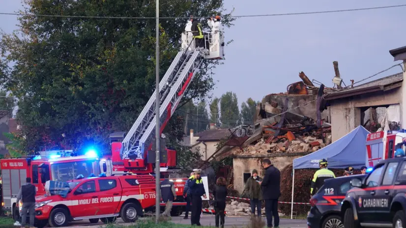 Carabinieri e vigili del fuoco nel tratto di strada chiuso in cui si è verificata l'esplosione, provocata da una famiglia di tre fratelli che ha fatto saltare una casa colonica, Castel d'Azzano (Verona), 14 ottobre 2025. ANSA / GIORGIO MARCHIORI