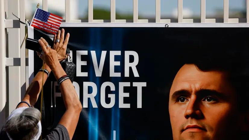 epa12393504 A person places an American flag at a makeshift memorial for conservative political activist Charlie Kirk outside the Turning Point USA headquarters in Phoenix, Arizona, USA, 20 September 2025. A memorial service for Kirk is scheduled to take place on 21 September in Glendale, Arizona. EPA/CAROLINE BREHMAN