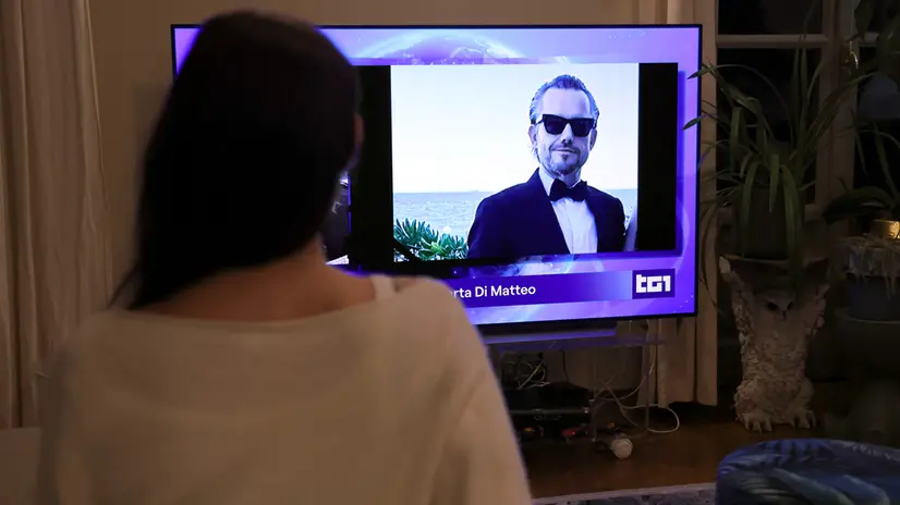 Una ragazza mentre segue al telegiornale la notizia di Pamela Genini. Milano 15 Ottobre 2025 ANSA / MATTEO BAZZI