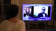 Una ragazza mentre segue al telegiornale la notizia di Pamela Genini. Milano 15 Ottobre 2025 ANSA / MATTEO BAZZI