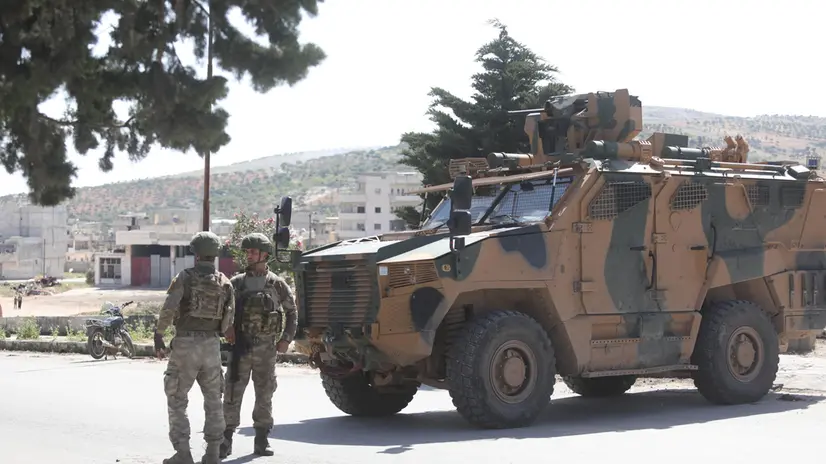 epa08417292 Turkish army soldiers guard the road and prevent civilians from ferrying to ensure protection for the Russian-Turkish joint patrol in Idlib, Syria, 12 May 2020. Turkey and Russia joint patrol on the M4 highway was hit by an artillery shell but without damage done. EPA/Yahya Nemah