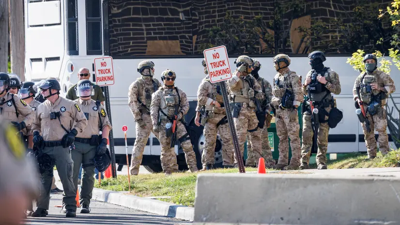 epa12460708 Illinois State Police officers (L) and ICE officers (R) guard the entrance of the ICE detention facility in Broadview, Illinois, USA, 17 October 2025. The demonstrations against ICE (U.S. Immigration and Customs Enforcement) are rooted in concerns about civil rights, local community safety, and alleged overreach by federal enforcement. EPA/CRISTOBAL HERRERA-ULASHKEVICH