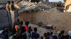 epa12460758 Locals gather to watch as an excavator works at the site where members of the Al-Qassam Brigades, the military wing of the Hamas movement, are searching for the bodies of Israeli hostages in an area in Hamad City, Khan Younis, in the southern Gaza Strip, 17 October 2025. EPA/HAITHAM IMAD