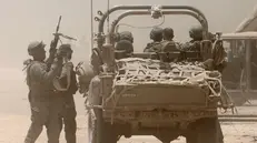 epa11452019 Israeli soldiers with a military vehicle at an undisclosed location near the border with the Gaza Strip, southern Israel, 02 July 2024. The Israeli military stated on 02 July that it continued operations in the areas of Shejaiya, Rafah, and central Gaza. More than 37,000 Palestinians and over 1,400 Israelis have been killed, according to the Palestinian Health Ministry and the Israel Defense Forces (IDF), since Hamas militants launched an attack against Israel from the Gaza Strip on 07 October 2023, and the Israeli operations in Gaza and the West Bank which followed it. EPA/ABIR SULTAN