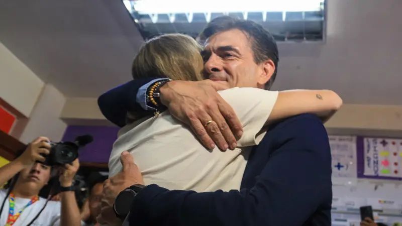 epaselect epa12465641 Presidential candidate for Bolivia's Christian Democratic Party (PDC), Rodrigo Paz (R), embraces a supporter at a polling station during the second round of elections to choose the president and vice president in La Paz, Bolivia, 19 October 2025. Bolivians will decide their president in a runoff between right-wing candidate Jorge Tuto Quiroga and centrist Rodrigo Paz. EPA/GABRIEL MARQUEZ