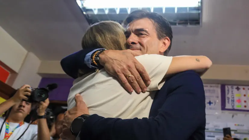 epaselect epa12465641 Presidential candidate for Bolivia's Christian Democratic Party (PDC), Rodrigo Paz (R), embraces a supporter at a polling station during the second round of elections to choose the president and vice president in La Paz, Bolivia, 19 October 2025. Bolivians will decide their president in a runoff between right-wing candidate Jorge Tuto Quiroga and centrist Rodrigo Paz. EPA/GABRIEL MARQUEZ