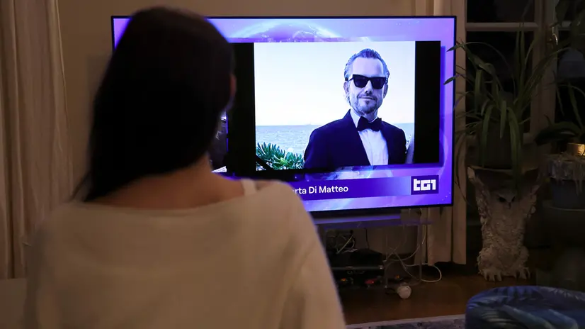 Una ragazza mentre segue al telegiornale la notizia di Pamela Genini. Milano 15 Ottobre 2025 ANSA / MATTEO BAZZI