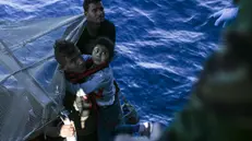 epa06294602 A young girl, one of 48 migrants rescued is lifted on board the Portuguese Navy Viana do Castelo Oceanic Patrol Ship, off the coast of Pozzallo, Sicily, Italy, 27 October 2017, (issued 28 October 2017). Reports state that 48 migrants were rescued on 27 October 2017 by the Portuguese Navy in the Mediterranean landed in Pozzallo on 28 October 2017 and were handed over to the Italian authorities 19 hours after being picked up from a vessel at risk of fire. EPA/JOSE SENA GOULAO