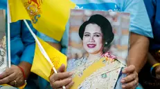 epa12295342 A Thai royalist holds a portrait of Thai Queen Mother Sirikit during a ceremony to celebrate her 93rd birthday at the Royal Ground Sanam Luang in Bangkok, Thailand, 12 August 2025. The Queen Mother of Thailand turned 93 on 12 August 2025. EPA/RUNGROJ YONGRIT