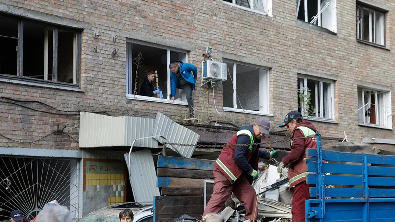 epa12472181 Communal workers and local people clean debris at the site of a damaged residential building after an overnight Russian strike in Kyiv, Ukraine, 22 October 2025, amid the ongoing Russian invasion. At least two people were killed and more than 20 others injured, including five children, after Russian strikes on Kyiv, the State Emergency Service of Ukraine reported. Across Ukraine, the attacks killed at least seven people, including two children, with regions including Kyiv, Odesa, Chernihiv, Dnipropetrovsk, Kirovohrad, Poltava, Vinnytsia, Zaporizhia, Cherkasy, and Sumy affected, according to President Zelensky. EPA/SERGEY DOLZHENKO