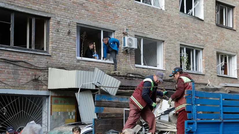epa12472181 Communal workers and local people clean debris at the site of a damaged residential building after an overnight Russian strike in Kyiv, Ukraine, 22 October 2025, amid the ongoing Russian invasion. At least two people were killed and more than 20 others injured, including five children, after Russian strikes on Kyiv, the State Emergency Service of Ukraine reported. Across Ukraine, the attacks killed at least seven people, including two children, with regions including Kyiv, Odesa, Chernihiv, Dnipropetrovsk, Kirovohrad, Poltava, Vinnytsia, Zaporizhia, Cherkasy, and Sumy affected, according to President Zelensky. EPA/SERGEY DOLZHENKO