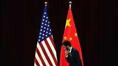 epa11259976 A Chinese official walks by the US and China national flags ahead of a bilateral meeting between US Treasury Secretary and Chinese Vice Premier, at the Guangdong Zhudao Guest House in Guangdong province, China, 05 April 2024. EPA/Andy Wong / POOL
