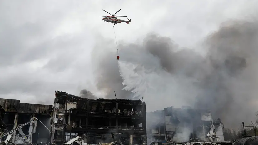 epaselect epa12480786 A firefighting helicopter douses a fire buring in a building after Russian strikes hit Kyiv, Ukraine, 25 October 2025, amid the Russian invasion. At least two people were killed and 13 others injured after Russian forces launched an overnight attack on Kyiv, the State Emergency Service of Ukraine reported. EPA/SERGEY DOLZHENKO