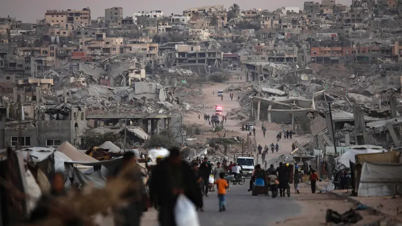 epa12482105 Palestinians walk among the ruins of their destroyed homes in Khan Younis, southern Gaza Strip, 25 October 2025. EPA/HAITHAM IMAD