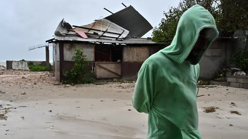 epaselect epa12486754 A man walks by a house damaged by the preliminary winds of Hurricane Melissa at Hellshire Fishing Beach in Portmore, Jamaica, 27 October 2025. Jamaican Prime Minister Andrew Holness said the government has a multifaceted plan to ensure a 'swift and effective' response to the storm’s imminent impact on Monday night and forecast to be the island’s strongest recorded storm. EPA/RUDOLPH BROWN