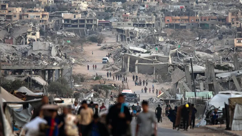 epa12482110 Palestinians walk among the ruins of their destroyed homes in Khan Younis, southern Gaza Strip, 25 October 2025. EPA/HAITHAM IMAD