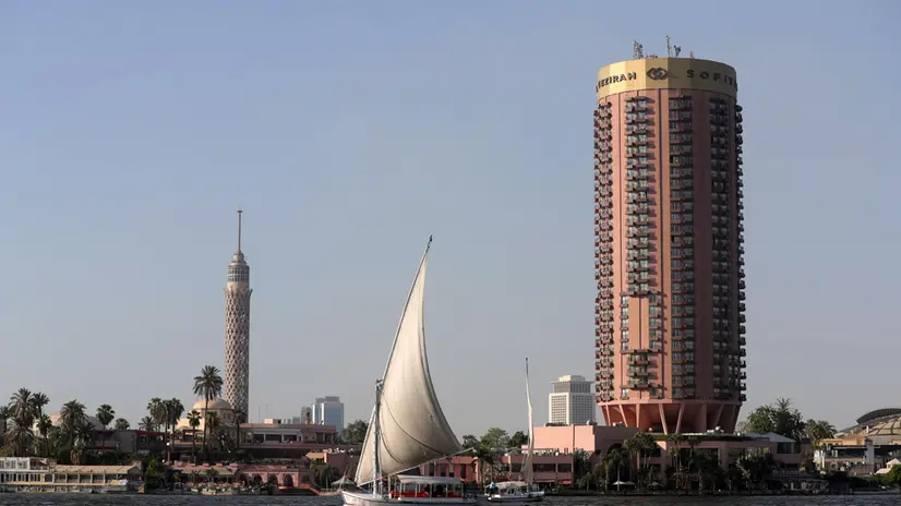 epa10795704 A sailboat on the Nile river with the Cairo Tower (L) and Sofitel Cairo Nile El Gezirah hotel in the background, in Cairo, Egyp, 11 August 2023. EPA/KHALED ELFIQI