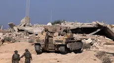 epa12430654 A photo taken while embedded with the Israeli Army and cleared by Israeli military censors shows Israeli army soldiers walking toward a tank at a position in the vicinity of the Jordanian Field Hospital in Gaza City, 03 October 2025 (issued 04 October 2025). Israel's military said on 04 October to advance readiness for the implementation of the first phase of the Trump plan for the release of the hostages while the same time make the safety of IDF troops a top priority and allocate all IDF capabilities to the Southern Command to ensure the protection of the troops. EPA/JACK GUEZ / POOL --PHOTO TAKEN DURING A CONTROLLED TOUR AND SUBSEQUENTLY EDITED UNDER THE SUPERVISION OF THE ISRAELI MILITARY--