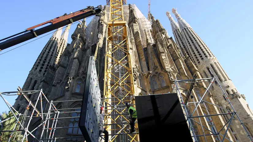 epa02427649 Worker prepare scaffolding for giant television screens that will be set up near Gaudi's Sagrada Famila basilica (background) in Barcelona, Spain, 03 November 2010, as part of the preparations for the visit of Pope Benedict XVI to the city on 07 November. EPA/TONI ALBIR