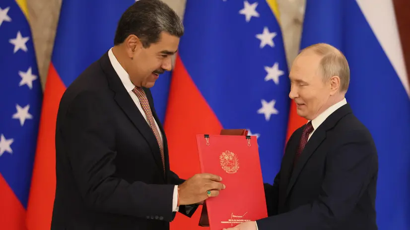 epa12080752 Russian President Vladimir Putin (R) and Venezuelan President Nicolas Maduro (L) exchange signed documents during their meeting at the Kremlin in Moscow, Russia, 07 May 2025. Russia will mark the 80th anniversary of the victory in World War II over Nazi Germany and its allies on 09 May. EPA/YURI KOCHETKOV