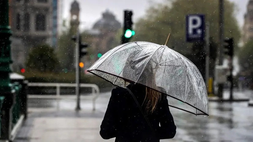 epa06659614 A woman walks under her umbrella in downtown San Sebastian, Spain, 10 April 2018. Strong rainfalls are expected to hit the region after a few days of clear skies. EPA/Javier Etxezarreta