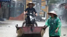 epa11597973 Men carry a motorbike on a boat through flood waters in Hanoi, Vietnam, 11 September 2024. Typhoon Yagi, which struck northern Vietnam over the weekend, triggered severe flooding in Hanoi. The Red River's rapid rise inundated communities along the riverbank, forcing residents to seek refuge in safer areas. As of 11 September, the Vietnam Disaster and Dyke Management Authority reported at least 152 fatalities and 140 missing persons due to the typhoon. EPA/LUONG THAI LINH