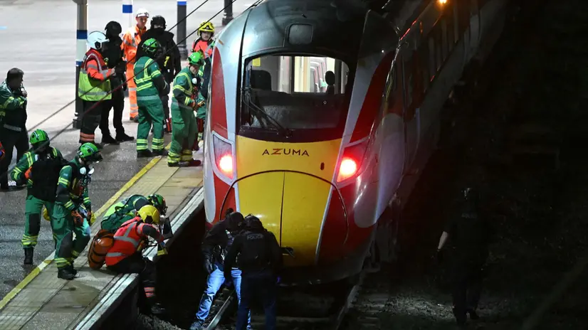 Police officers and members of the Emergency services search the track beneath an LNER Azuma train at Huntingdon Station in Huntingdon, eastern England, on November 1, 2025, following a stabbing on a train. UK police said they had arrested two suspects Saturday as "a number of people" were taken to hospital after a stabbing on a train in Cambridgeshire, eastern England. "We are currently responding to an incident on a train to Huntingdon where multiple people have been stabbed," British Transport Police said on X, adding that "two people have been arrested". (Photo by JUSTIN TALLIS / AFP)