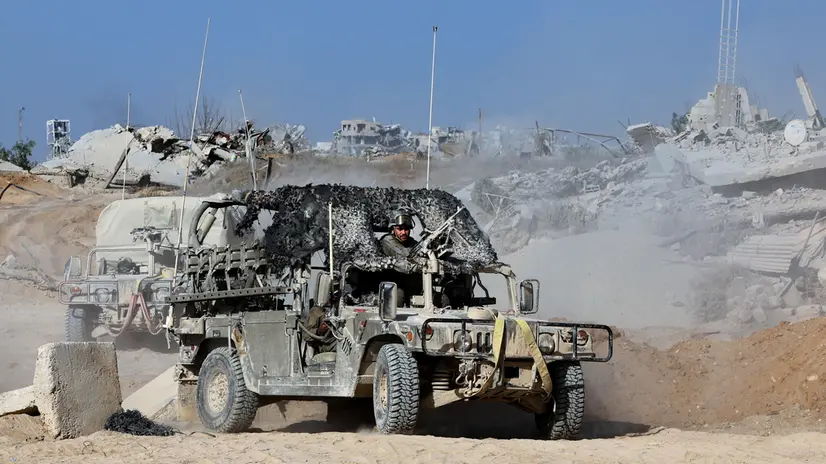 epa12430649 A photo taken while embedded with the Israeli Army and cleared by Israeli military censors shows Israeli army soldiers riding military vehicles in front of war-destroyed buildings in the vicinity of the Jordanian Field Hospital in Gaza City, 03 October 2025 (issued 04 October 2025). Israel's military said on 04 October to advance readiness for the implementation of the first phase of the Trump plan for the release of the hostages while the same time make the safety of IDF troops a top priority and allocate all IDF capabilities to the Southern Command to ensure the protection of the troops. EPA/JACK GUEZ / POOL --PHOTO TAKEN DURING A CONTROLLED TOUR AND SUBSEQUENTLY EDITED UNDER THE SUPERVISION OF THE ISRAELI MILITARY--