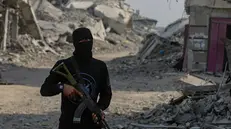 epa12499090 Fighters of the Al-Qassam Brigades, the military wing of the Hamas movement, stand guard as they search for the bodies of Israeli hostages alongside Red Cross workers in the east of the Gaza Strip, 02 November 2025. As part of a US-brokered ceasefire agreement between Israel and Hamas, heavy machinery was deployed to Khan Yunis to assist in the recovery of Israeli hostage bodies. EPA/MOHAMMED SABER