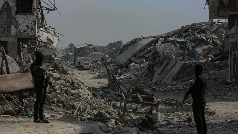 epa12499083 Fighters of the Al-Qassam Brigades, the military wing of the Hamas movement, stand guard as they search for the bodies of Israeli hostages alongside Red Cross workers in the east of the Gaza Strip, 02 November 2025. As part of a US-brokered ceasefire agreement between Israel and Hamas, heavy machinery was deployed to Khan Yunis to assist in the recovery of Israeli hostage bodies. EPA/MOHAMMED SABER