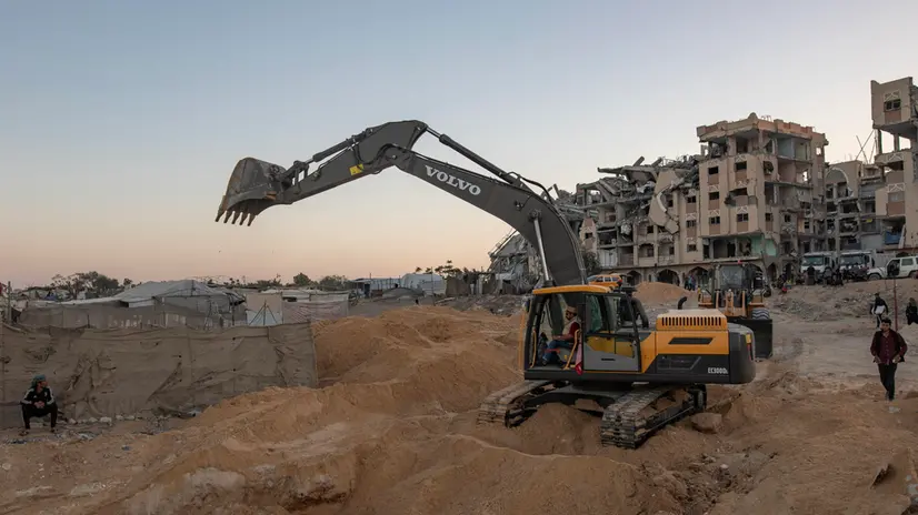 epa12486645 Palestinians watch as machinery and workers from Egypt search the rubble of damaged buildings for the bodies of hostages in the Hamad City area of Khan Yunis, southern Gaza Strip, 27 October 2025. As part of the US-brokered ceasefire agreement between Israel and Hamas, Egyptian teams deployed to Khan Yunis with heavy machinery to assist in the recovery of Israeli hostage bodies. EPA/HAITHAM IMAD