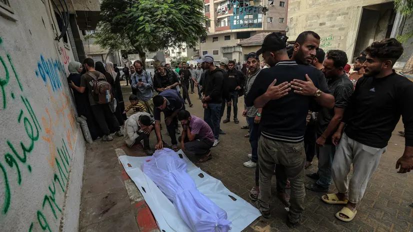 epa12489854 Relatives mourn over the body of a man killed in an Israeli airstrike, at Al Shifa hospital in Gaza City, 29 October 2025. According to the Palestinian Ministry of Health in Gaza, at least 110 Palestinians were killed and scores wounded following the latest Israeli air strikes on the Gaza Strip. EPA/MOHAMMED SABER