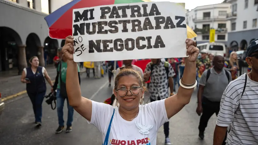 epa12494372 A woman holds a sign during a pro-government demonstration in Caracas, Venezuela, 30 October 2025. Supporters of President Nicolas Maduro marched against the US military deployment in the Caribbean Sea, which Washington says targets drug trafficking. Maduro claims the mission is a cover to remove him from power. EPA/RONALD PENA R